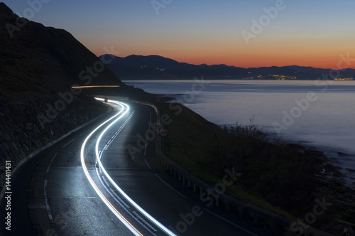 Car lights on the road at night by the sea, Gipuzkoa