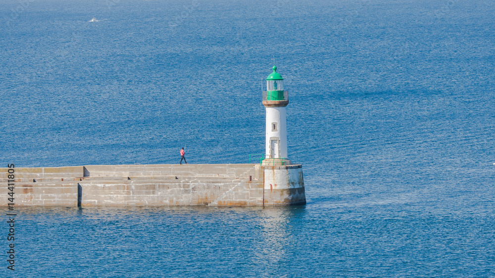     Brittany, ile de Groix, harbor Port-Tudy, green lighthouse and a angler on the quay
