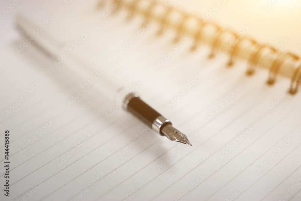 pen on the desk,Open a blank white notebook on wooden table,vintage color,selective focus pen on the desk,Open a blank white notebook on wooden table,vintage color,selective focus