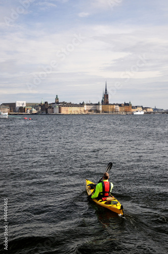  Cityscape of Stockholm with Canoe kayak flowing in the river.