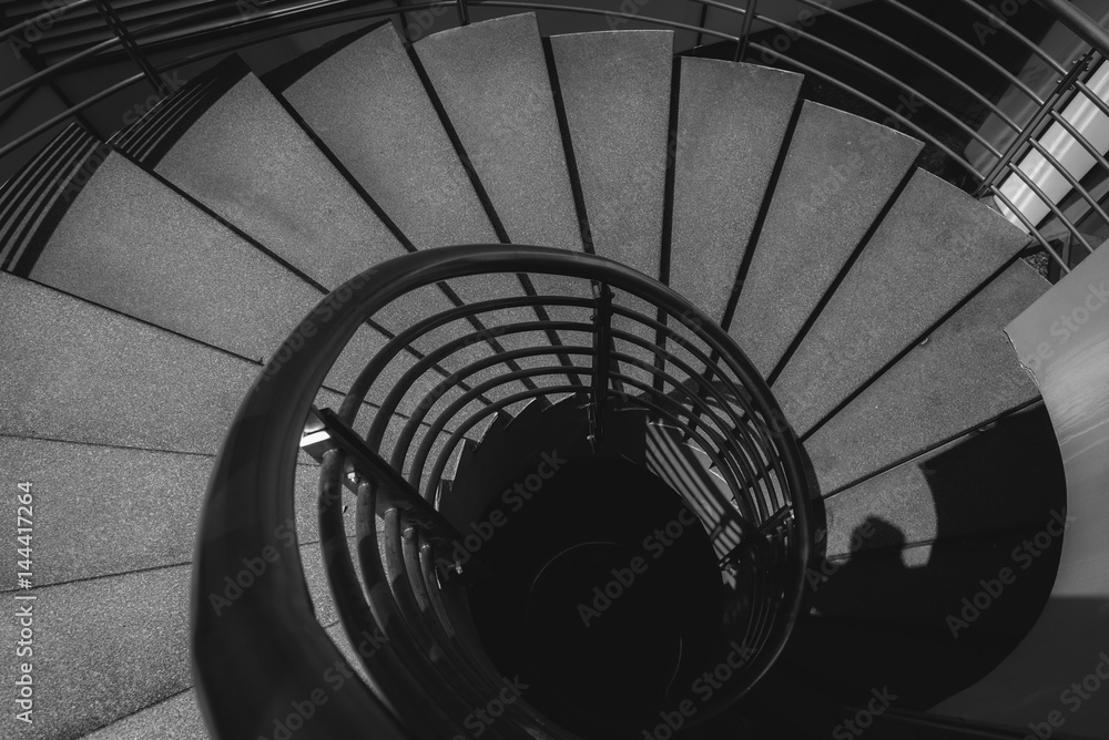 Naklejka premium Black and white image of spiral staircase.