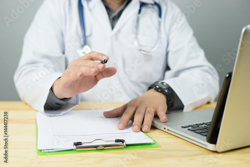Doctor and patient are discussing something  just hands at the table explaining prescription to victim stethoscope and laptop computer on desk in hospital healthcare and medical  insurance concept