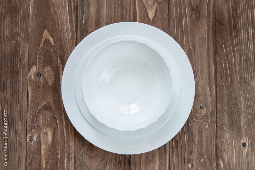 Bottom plate and soup plate isolated on wooden background Bottom plate and soup plate isolated on wooden background