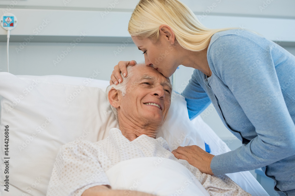 Obraz premium Daughter kissing senior father