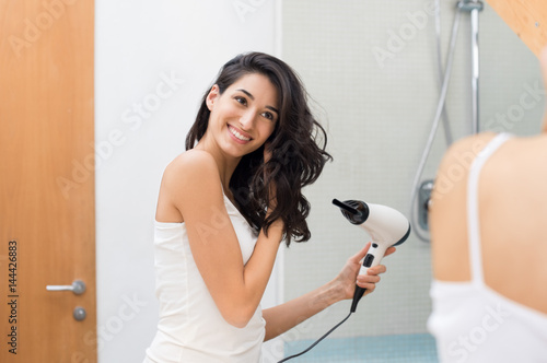 Foto Woman using hair dryer