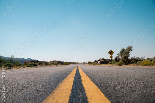Straight road in California Desert	A low angle shot of an endless desert road in a California Desert. Road to success. 