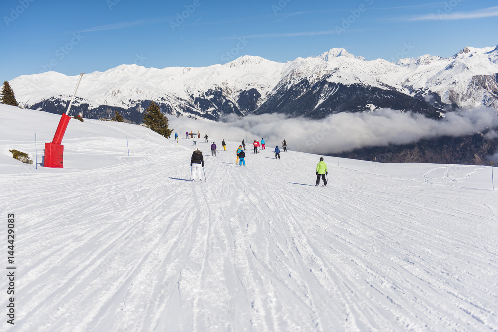 Skiers on a piste in alpine ski resort