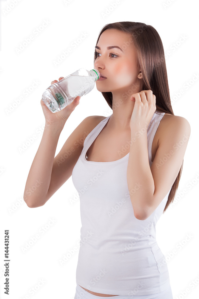 Beautiful healthy young girl drinking a bottle of pure clean water. Pretty woman holding a bottle of water in her hands on isolated background. Beautiful healthy young girl drinking a bottle of pure clean water. Pretty woman holding a bottle of water in her hands on isolated background.