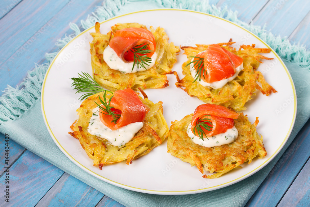 Potato Pancakes With Salmon. Vegetable fritters with fish. Latkes on a plate Potato Pancakes With Salmon. Vegetable fritters with fish. Latkes on a plate