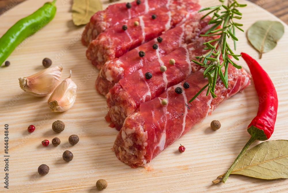 Raw cevapcici dish of mixed meats, the food of the Balkans. Minced meat and bacon. Raw cevapcici dish of mixed meats, the food of the Balkans. Minced meat and bacon.