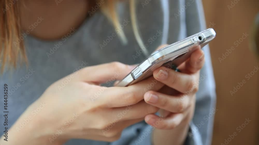 Young asian woman using smart phone and typing fast text messages on it Young asian woman using smart phone and typing fast text messages on it