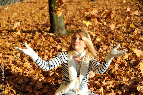 young woman playing with autumn leaves photo