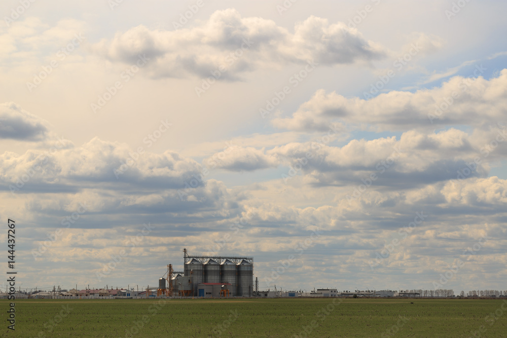 Small factory in the field on the sky background Small factory in the field on the sky background