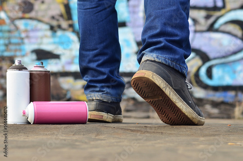 A photography of a certain number of paint cans against the graffiti background photo