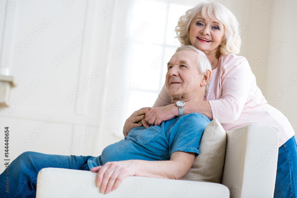 Happy senior couple embracing and relaxing together at home Happy senior couple embracing and relaxing together at home