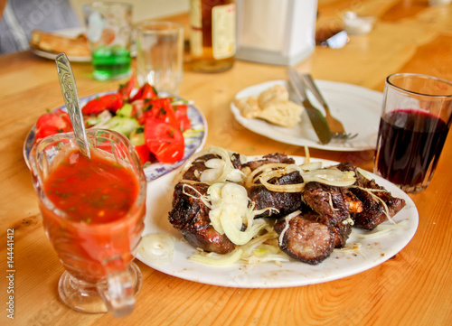 Traditional Georgian food. National cuisine. Barbecue with sauce satsebeli and glass of the wine