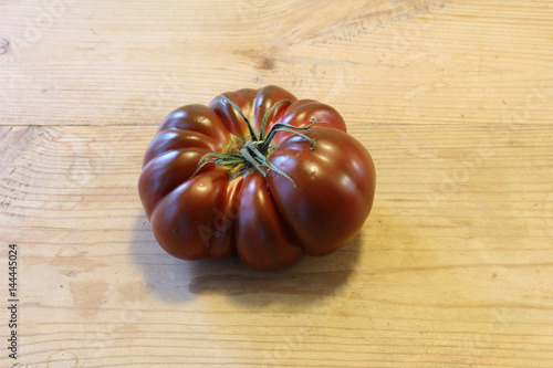 Purple heirloom tomato on a light wood table

