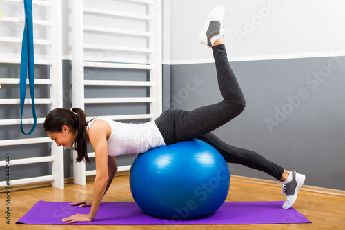 Beautiful young woman exercising with pilates ball.