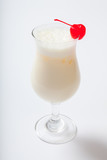 milk cocktail with a cherry in a tall glass