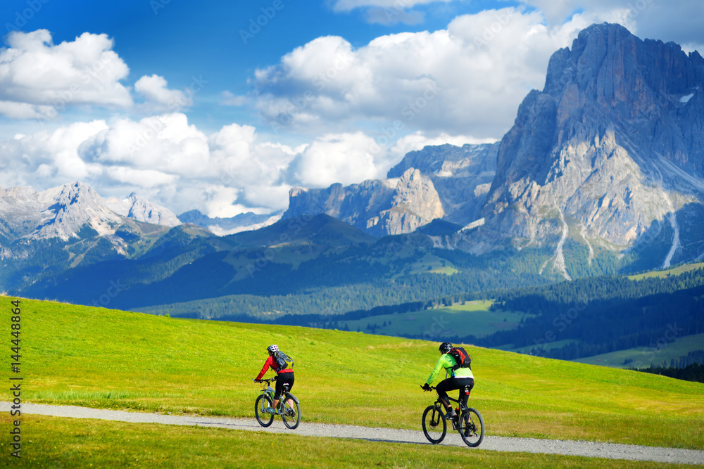 Φωτογραφία Tourists cycling in Seiser Alm, the largest high altitude Alpine meadow in Europe, stunning rocky mountains on the background