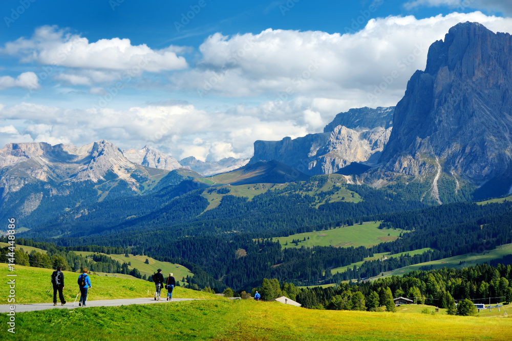 Φωτογραφία Tourists hiking in Seiser Alm, the largest high altitude Alpine meadow in Europe, stunning rocky mountains on the background