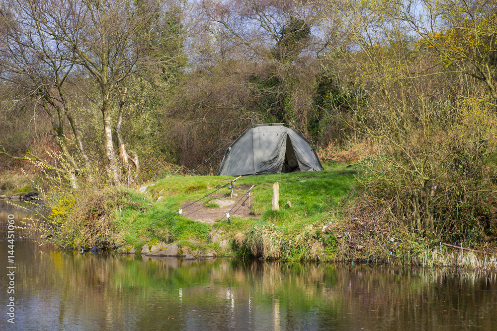 A two man tent pitched on a piece of ground beside the lake at the old lead mines workings in Conlig, County Down in N Ireland on an early spring day. The ground and lake are contaminated with lead
