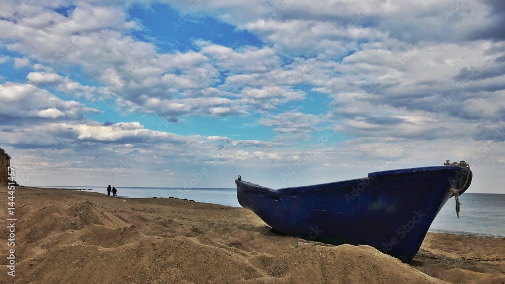 Abandoned boat on the desert island, two people on the beach Abandoned boat on the desert island, two people on the beach