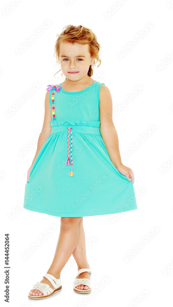 Beautiful little tanned girl in a blue dress. Beautiful little tanned girl in a blue dress.