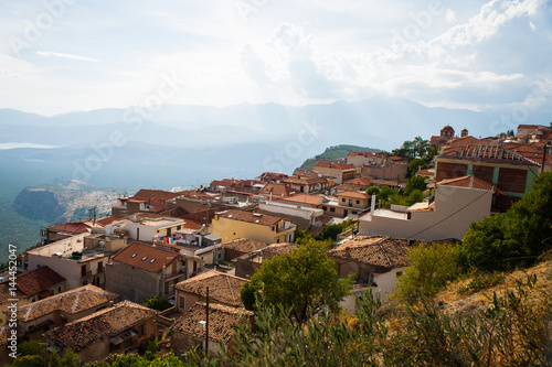 Greece, Delphi, August 2016, beautiful sun shining through the clouds lightning just part of hill. Panorama from one of city restaurants