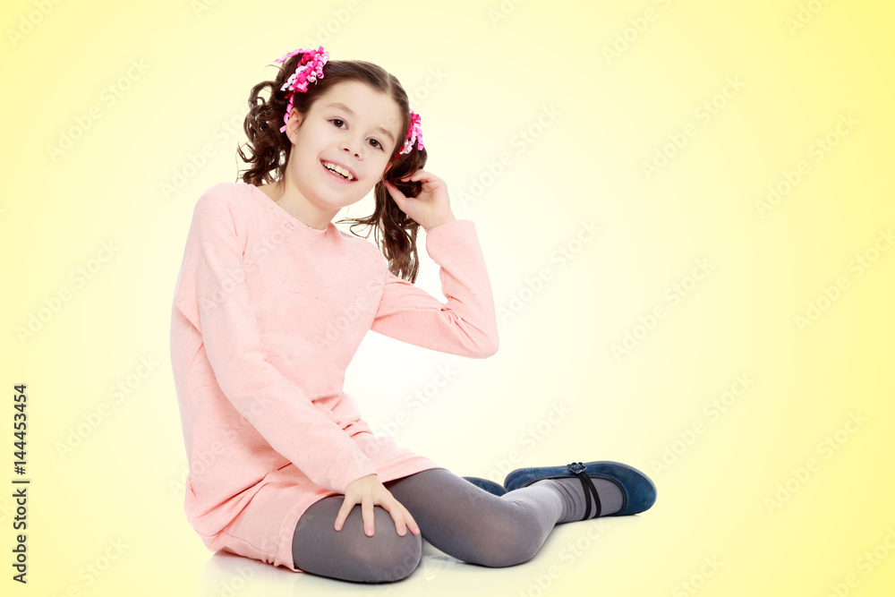 Little girl sitting on the floor and straightens hair. Little girl sitting on the floor and straightens hair.
