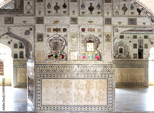 Mirror mosaic, marble flowers and colored ornament on the walls and arches of an ancient palace Sheesh Mahal, 17th century, in the old Amber Fort, Jaipur, India photo