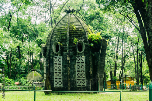 A dome house with mossy wall and ferns in the middle of grass yard photo taken in Ragunan zoo Jakarta Indonesia