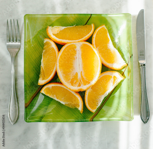 Cut orange on a plate photo