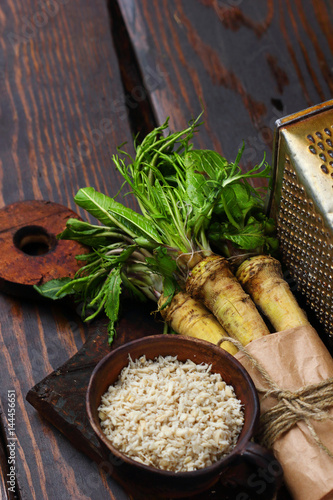 raw horseradish roots on wooden background. horseradish with leaves.Homemade wassabi photo