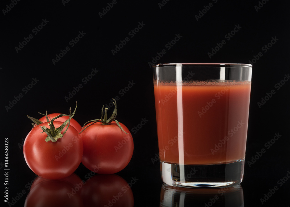 Still life with tomato juice in glass on black background Still life with tomato juice in glass on black background