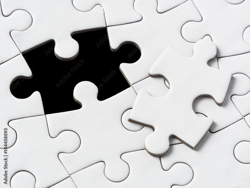 A missing piece of puzzle in a black background A missing piece of puzzle in a black background