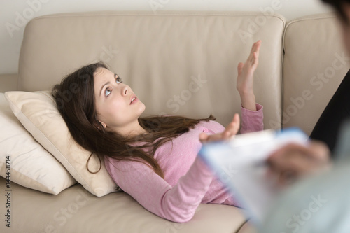 Photos Beautiful young woman lying on couch at psychologists office, speaking about per