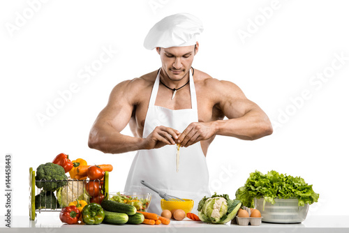 Man bodybuilder in white toque blanche and cook protective apron