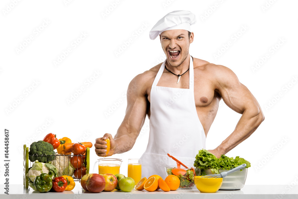 Man bodybuilder cook, cooking freshly squeezed juice and vegetables salad Man bodybuilder cook, cooking freshly squeezed juice and vegetables salad