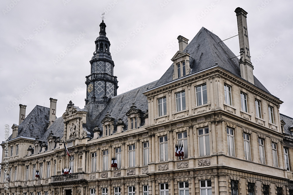 Historic building with clock tower in the city of Reims, France.