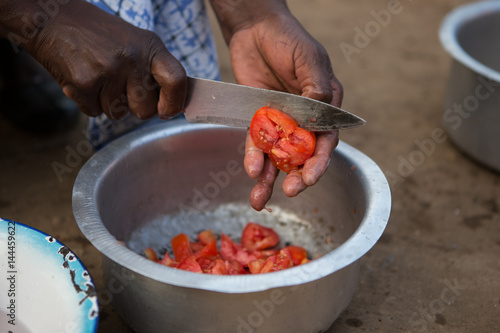 Cutting tomatoes for dinner in a Malawian Village, Africa