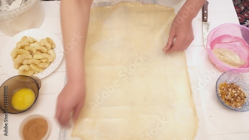 Woman's hands stretching the dough on the table