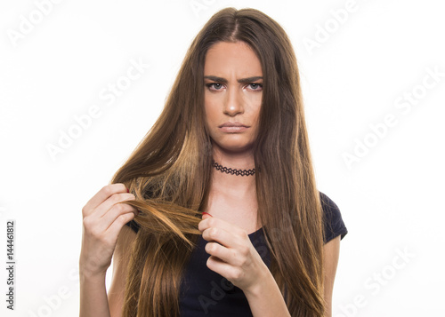 beautiful girl supprised and unhappy with her damaged and dry hair