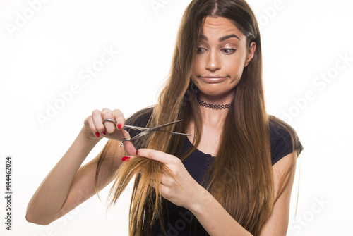 beautiful girl supprised and unhappy with her damaged and dry hair photo