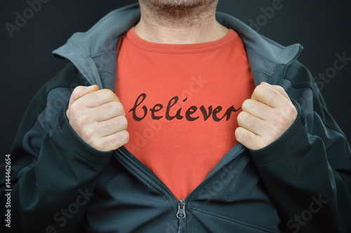 Leinwand Poster a man with the word believer on his red t-shirt