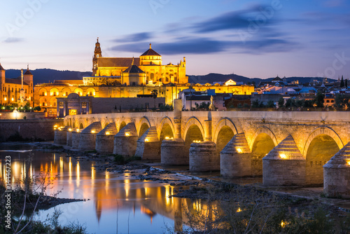 Illuminated Roman Bridge and Mosque-Cathedral at twilight in Cordoba, Spain © marcin jucha