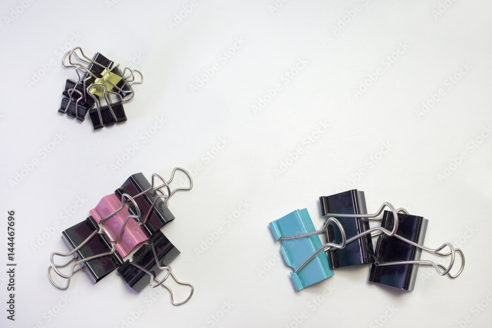 stacks of metal binder clips for paper. different sizes and colors