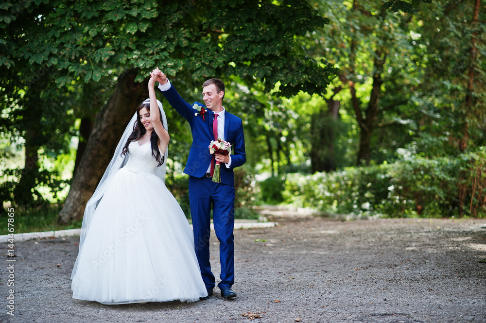 Wedding couple in love hugging at park at sunny day.