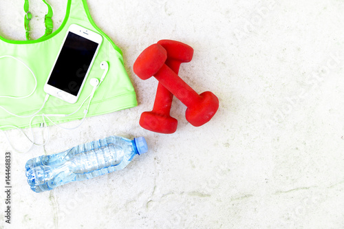 Fitness accessories. Sport bra,bottle of water, earphones, dumbbells
