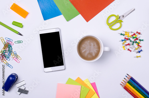 School and office supplies, smartphone and cup of coffee on a white background.